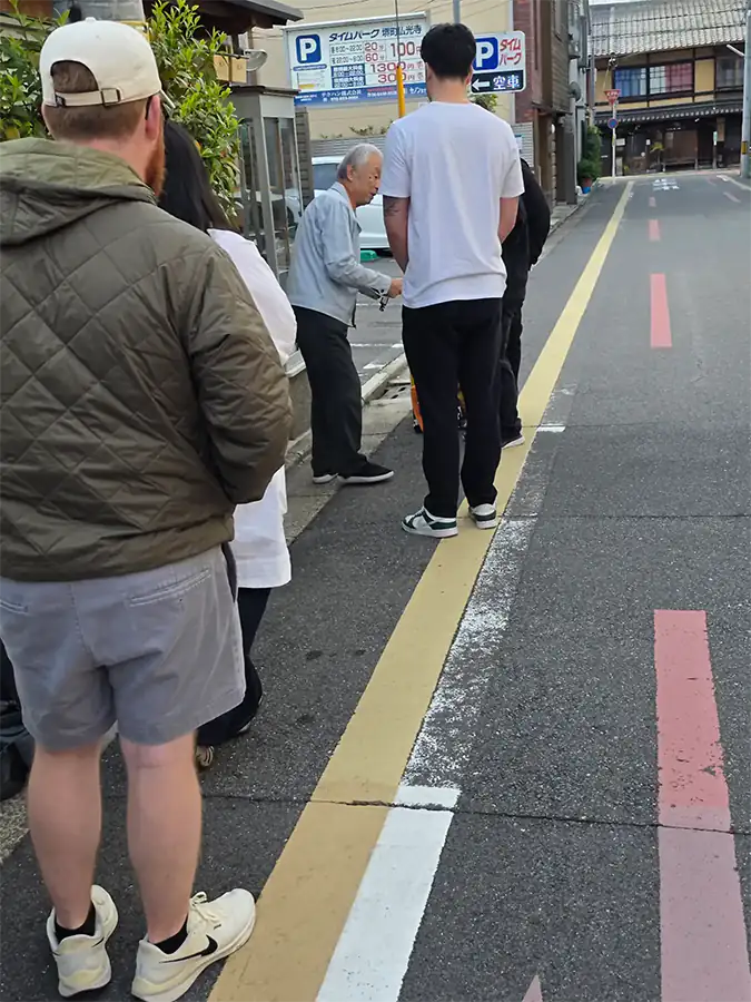 Wartende vor Hayakawa Hamonoten am frühen Morgen in einer Gasse in Kyoto
