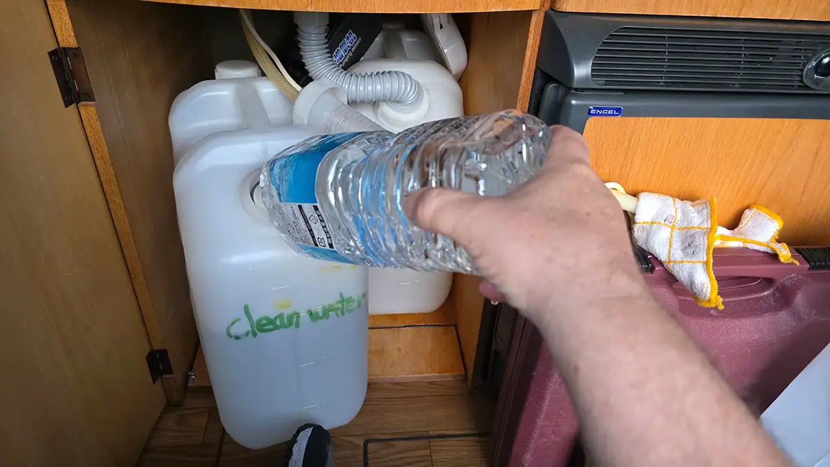 Filling fresh water into the campervan's canister using a 1.5-liter PET bottle