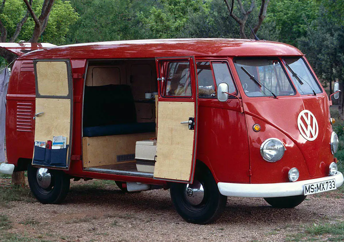 Roter VW T1 Feuerwehr-Bulli als Camper mit geöffneter Schiebetür und Holzausbau